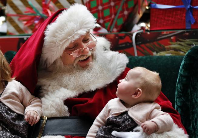 A man portraying Santa Claus talks to 6-month-old Aubree-Jane Halladay, of Scarborough, Maine, at a mall in South Portland, Maine on Thursday, Dec. 19, 2013. Andrew Chesnut, the Bishop Walter F. Sullivan Chair in Catholic Studies at Virginia Commonwealth University, said depictions of Santa Claus as a white man came about mainly because he was a European import, a blend of the Dutch Sinterklaas and British folklore character Father Christmas, with elements of Saint Nicholas, a 4th-century Greek bishop in modern-day Turkey. (AP Photo/Robert F. Bukaty)